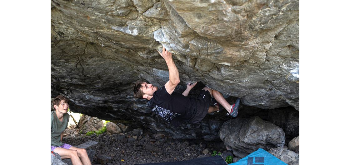 Boulderer on steep underside of boulder