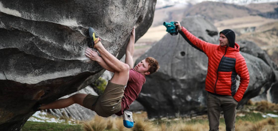Climber on slopey holds of boulder problem
