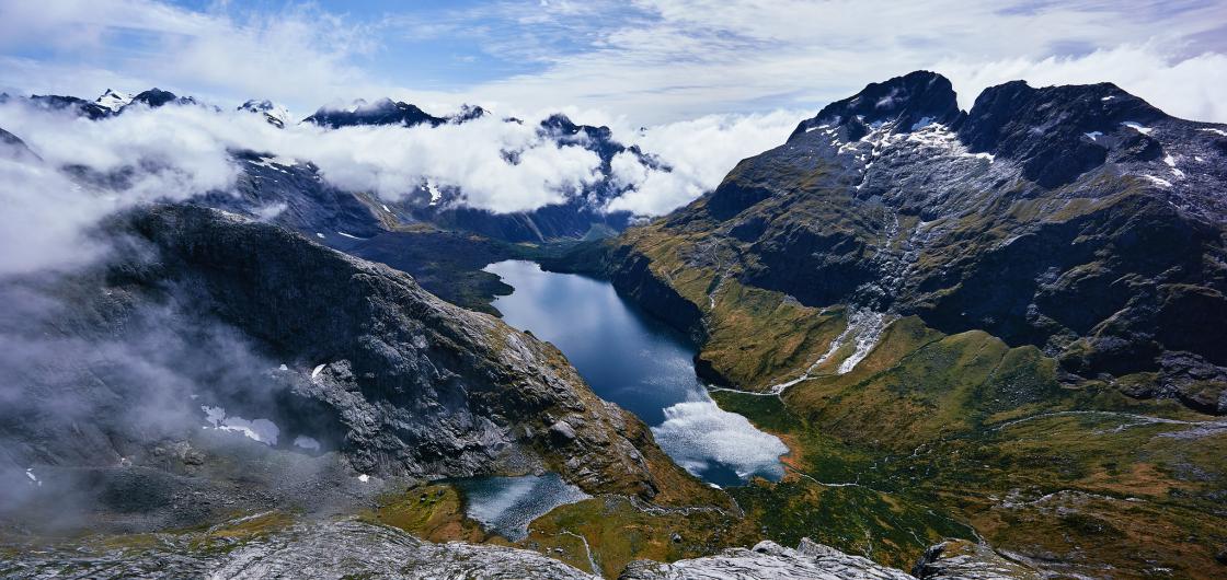 A view of a lake in a basin surrounded by steep mountains