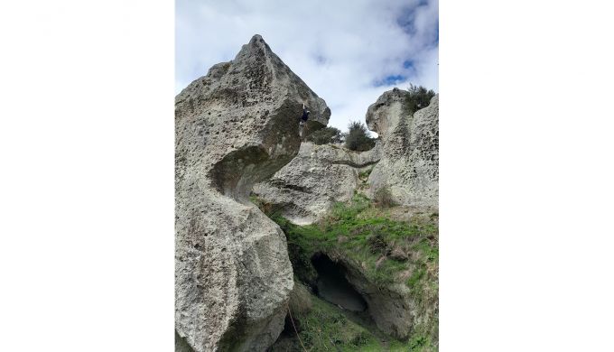 Climber on absurdly-shaped rock formation
