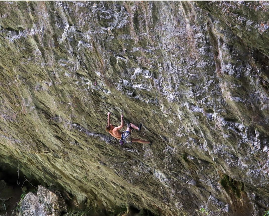 Climber on very overhanging wall and just holding on by their very fingertips