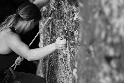 female side pulling on rock