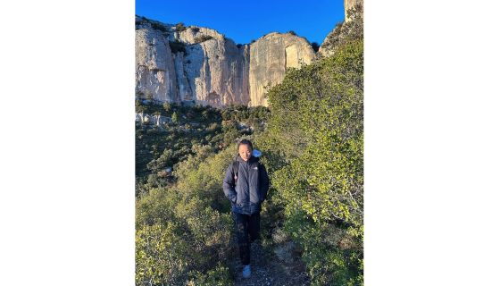 Climber below cliffs