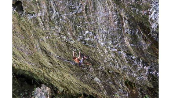 Climber on very overhanging wall and just holding on by their very fingertips