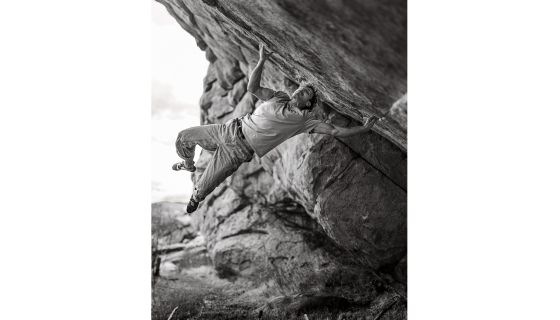 Climber on mega hard boulder with muscles in weird places