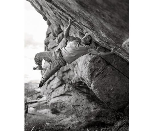 Climber on mega hard boulder with muscles in weird places